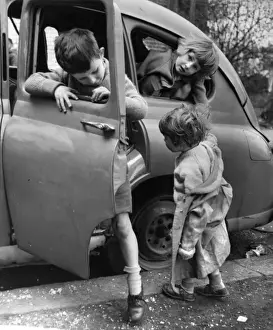 Children playing with a car in a Balham street, SW London