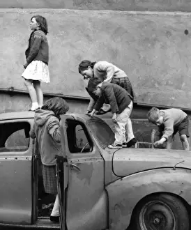 Children playing with a car in a Balham street, SW London