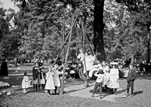 Playground Prints: Children playing on the swings in a park playground in Ameri
