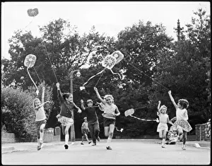 Children race down the street with kites