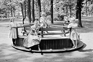 Clark Prints: Children riding a Merry-go-round roundabout in Clark Park, D