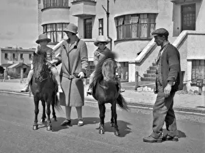 Sunhat Prints: Two children riding ponies in a street