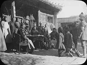 China - 2 men kneeling before a group