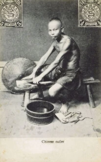 China - A Chinese cutler, sharpening a Chinese Cleaver