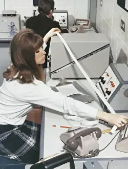 Colleague Prints: A computer technician with data tape