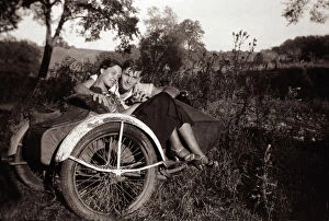 Couple together with 1948 Harley Davidson motorcycle sidecar