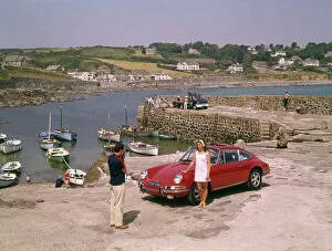 Sports Gallery: Couple with red car at Coverack, Cornwall