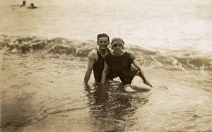 Swimsuits Prints: Couple sitting in surf - British seaside candid photograph