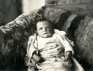 Cross looking baby on a sofa