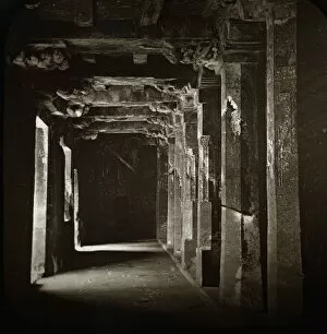 A dark corridor with many carved columns on each side