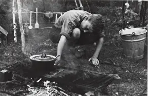Dutch boy scout cooking at camp, Holland