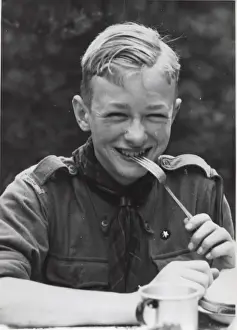 Grinning Prints: Dutch boy scout eating at camp, Holland