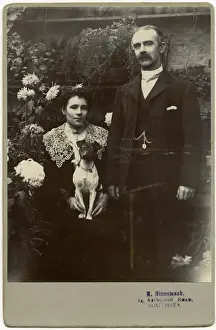 Edwardian couple with terrier dog in a garden