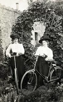 Siblings Collection: Two Edwardian women with their bicycles in a garden