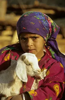 Tribes Prints: Egypt - a Bedouin girl cuddles a goat; a small