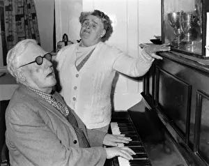 Elderly blind couple having a sing-song at the piano