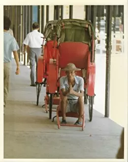 Images Dated 19th July 2016: Elderly Chinese man in an empty red rickshaw