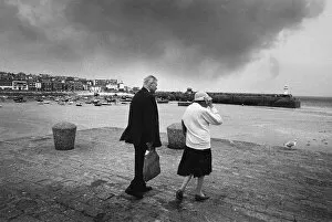 Elderly couple brave strong winds, West Pier, St Ives