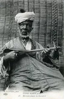 Lute Gallery: Elderly Moroccan man playing a sintir, also known as the guembri, gimbri or hejhouj