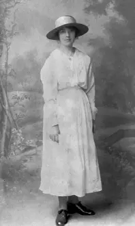 Elegant woman in long white dress and wide-brimmed hat