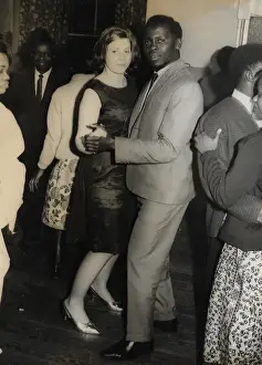 English girl and African man with other people on the dance