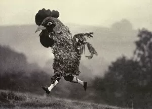 Images Dated 13th April 2022: English Lunacy - A man dressed as a chicken running wild and free across a field and up a small hill