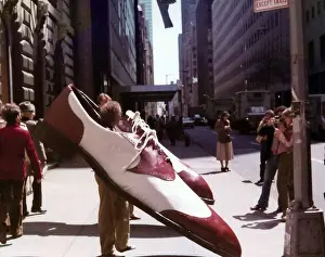 Exhibition image of men wearing large shoes