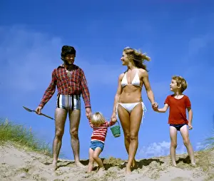 Dunes Prints: Family of four holding hands on a beach, West Country