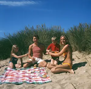 Family of four with picnic on beach