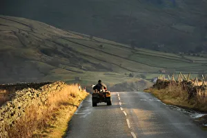 Photography by Philip Dunn Collection: Farmer and his dog on a quad bike Buttertubs Pass, Swaledale