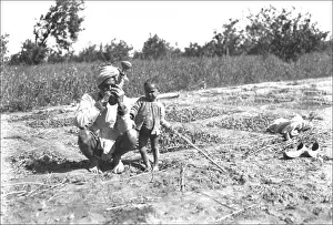 Father and child in a field, India