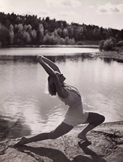 Female gymnast by lake stretch