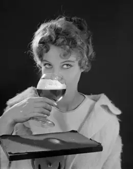 Colin Prints: Female model (Gillian Watt) holding up a glass of beer
