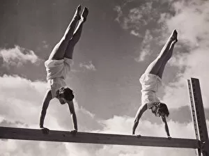 Two females handstands on beam