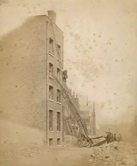 A firefighter in action on a wheeled ladder escape