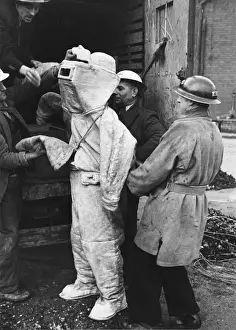 Asbestos Prints: Firefighter putting on his asbestos suit in England during the air raids of World War II