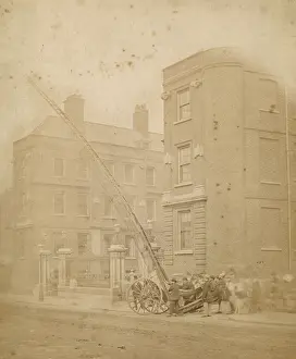 Firefighters in action in a street with a wheeled ladder