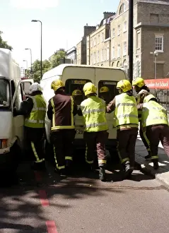 Firefighters pushing a broken down Ford transit van