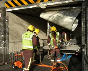 Firefighters working to remove van trapped under bridge