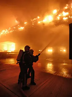 Firefighters working at scene of large warehouse fire