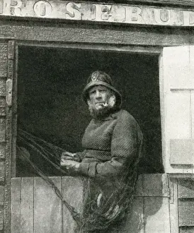 Fisherman repairing his nets, East Anglia, England