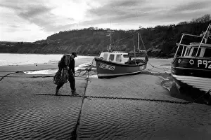 Ceredigion Prints: Fisherman walks up the beach - New Quay, Wales