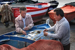 Images Dated 4th September 2019: Fishermen play cards on a fishing boat at Funchal