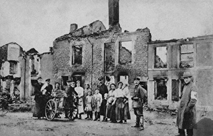 Images Dated 12th April 2012: A French family stand outside their ruined home