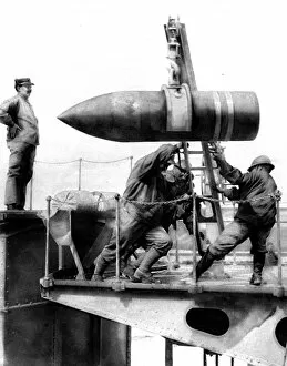 French soldiers hoisting an artillery shell