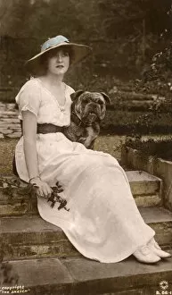 Gabrielle Collection: Gabrielle Ray, English actress, with a dog in a garden