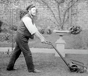 Antique Collection: Gardener mowing a lawn with a Thomas Green lawnmower