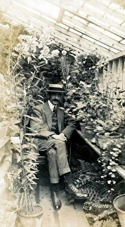 Suburban Collection: Gentleman Gardener seated proudly in small home greenhouse