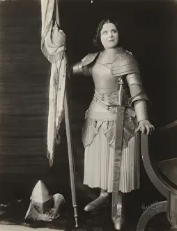 Geraldine Farrar, dressed in costume as Joan of Arc, holding