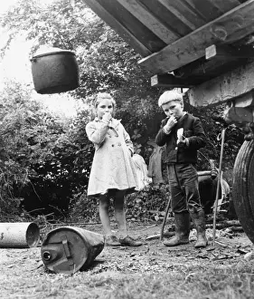 Gipsy boy and girl, eating out of doors